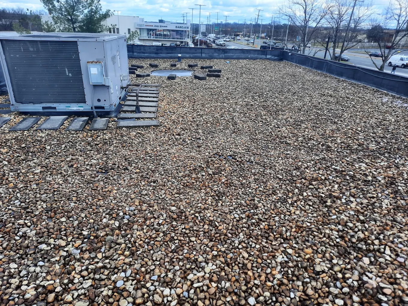 Commercial ballasted flat roof with gravel surfacing and HVAC walkway by J Castillo Construction