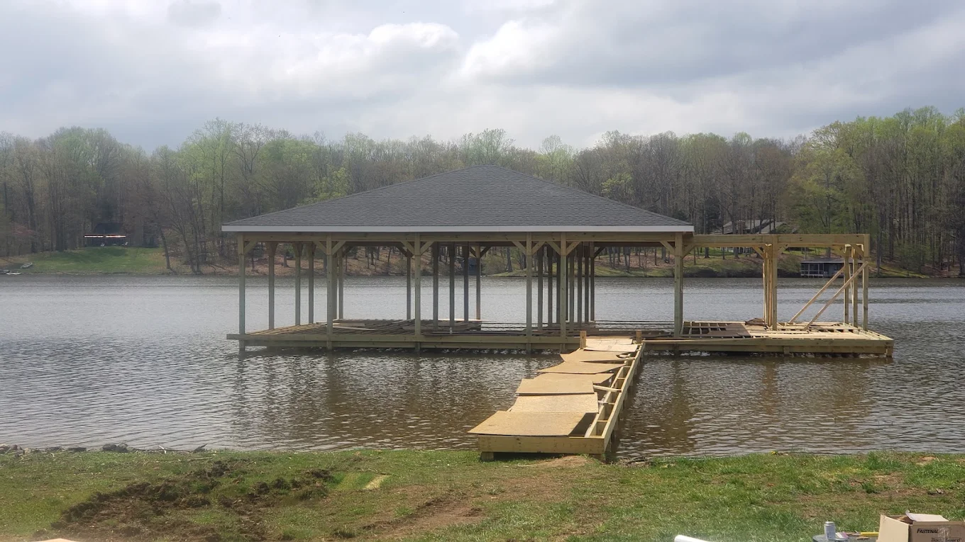 Custom wooden boat house with grey shingled hip roof under construction by J Castillo Construction