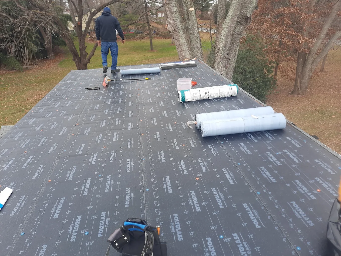 J Castillo Construction crew installing Polyglass flat roof membrane on a residential home